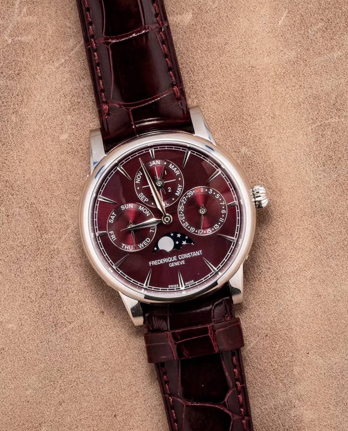 Frederique Constant perpetual calendar watch with a burgundy dial and moon phase, on a burgundy leather strap